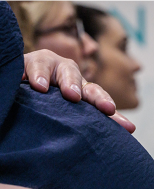 Dettaglio della mano di una donna incinta appoggiata sulla pancia