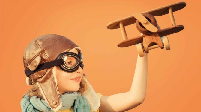 Bambina con modellino di aereo in mano